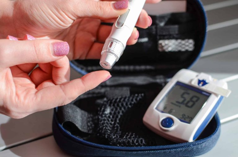 Blood glucose meter, test strips and lancet used by a person with diabetes to check blood sugar