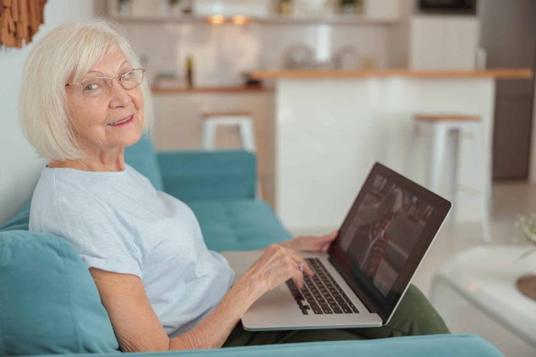 Older woman relaxing with a drink in the kitchen of her own home, living independently