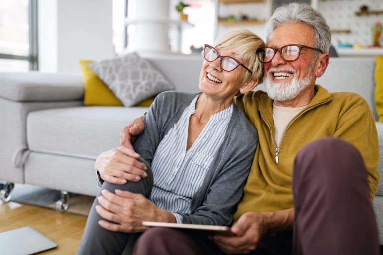 Happy senior couple embracing at home while enjoying their retirement together