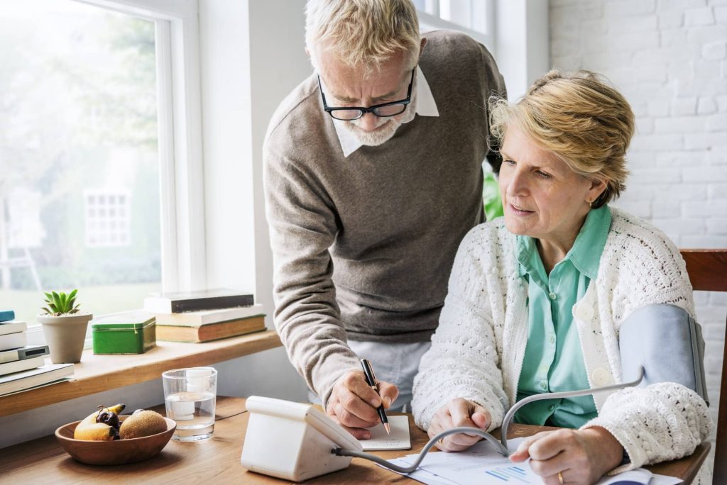 A senior adult checking their blood pressure at home