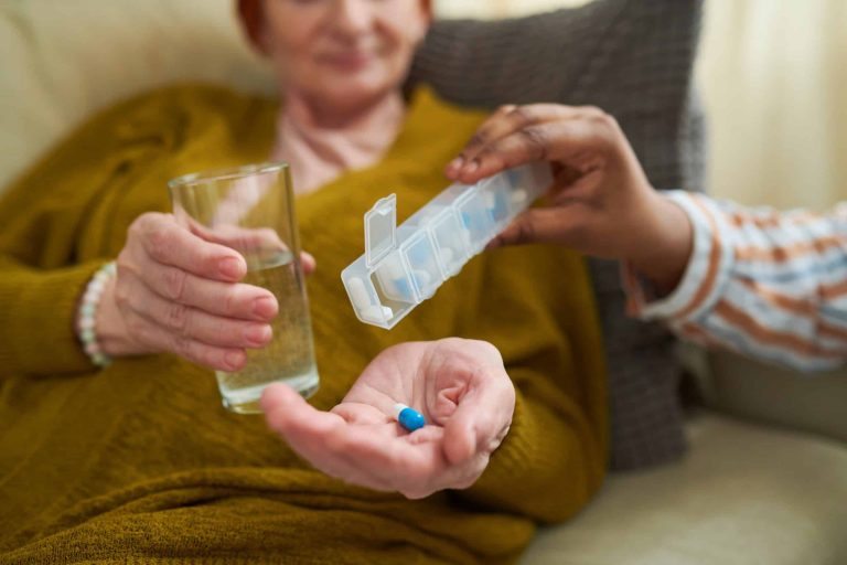 Senior woman at home sorting her prescription medications from pill bottles